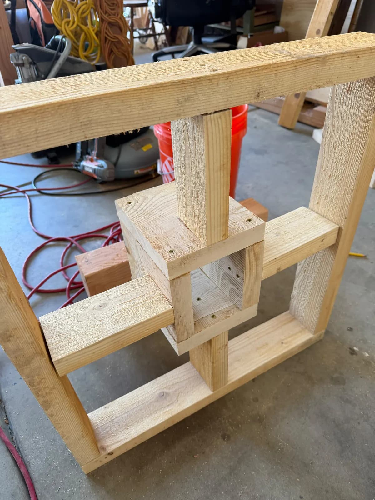 Unfinished wooden cross base with a center socket braced to a square outer frame