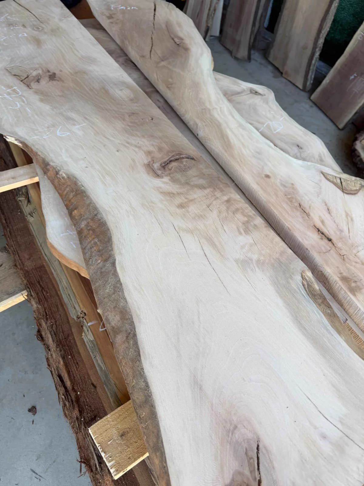 Unfinished live-edge sycamore slabs stacked together