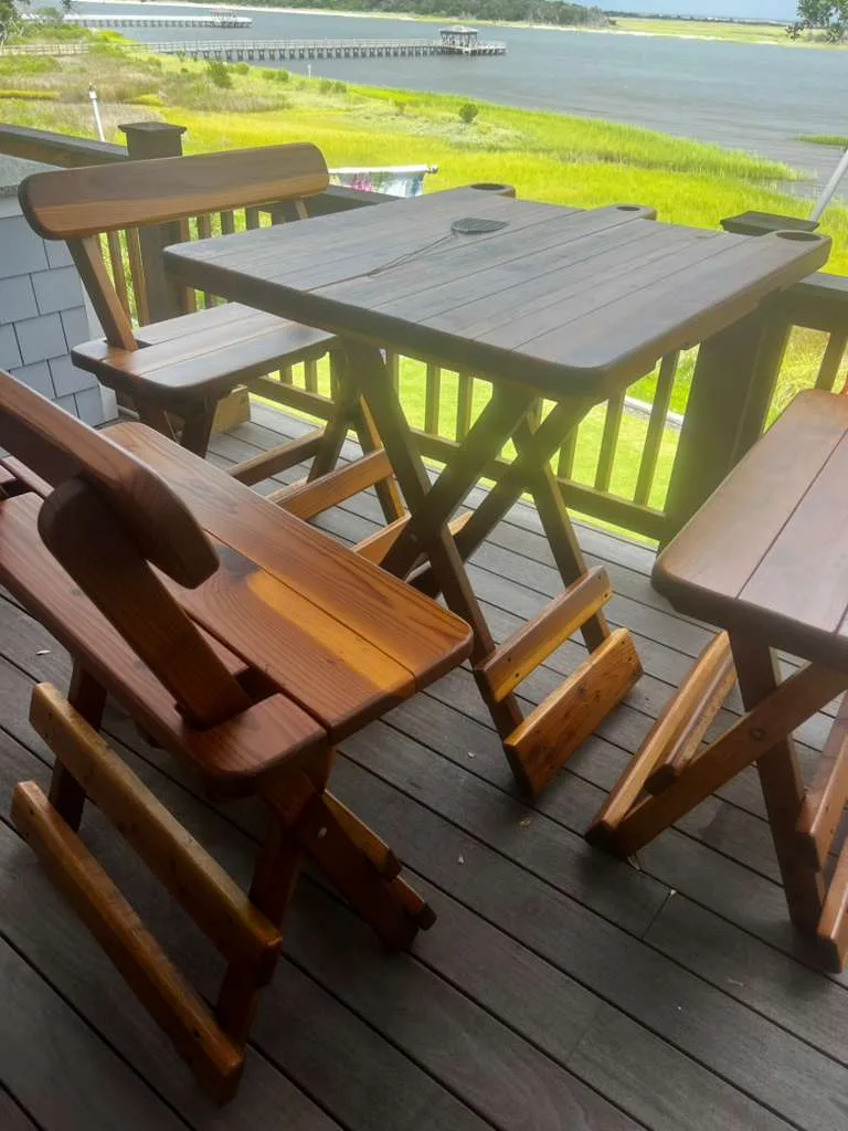 Bar-height Michael Frazier redwood table with benches on a deck