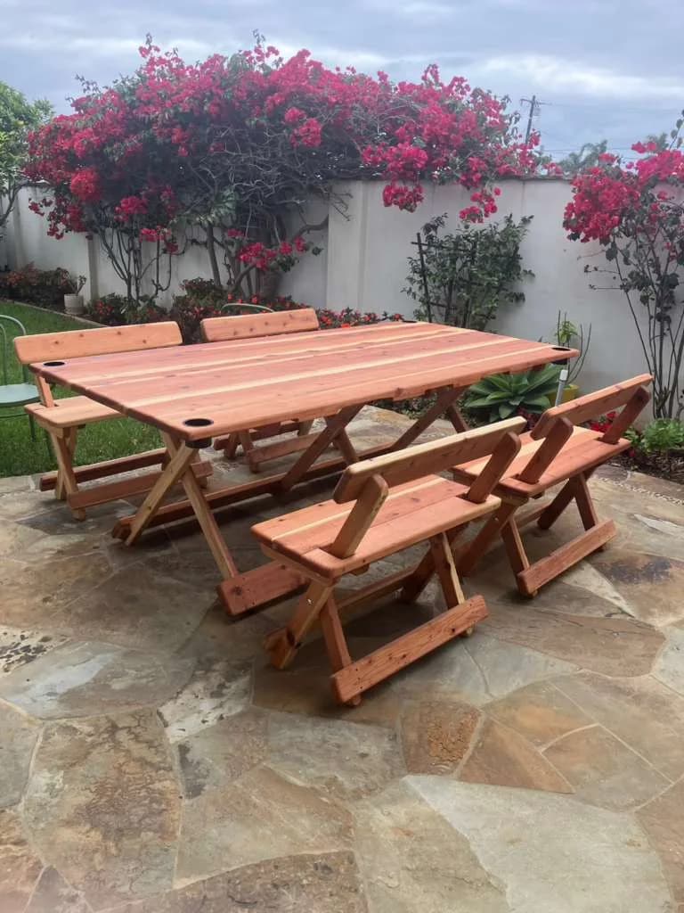 Michael Frazier redwood table and benches in a courtyard with flowering vines